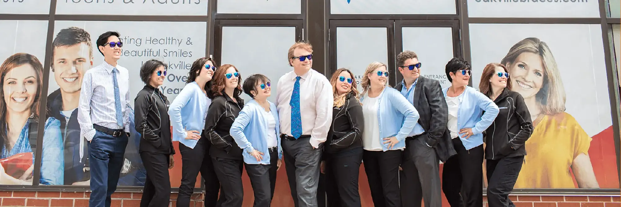 The Oakville Orthodontics team in front of the colourful art wall